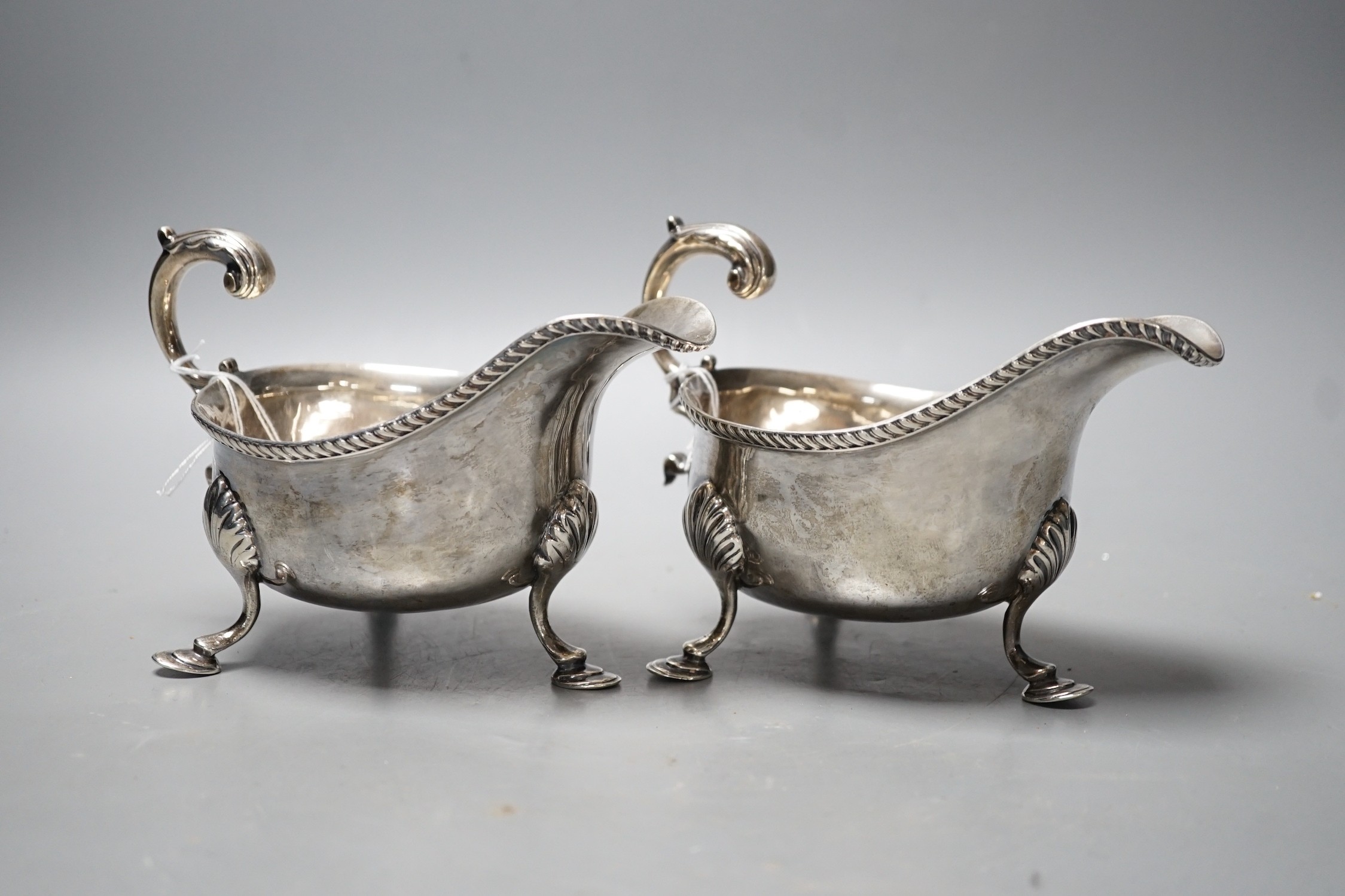 A pair of Edwardian silver sauceboats, with flying scroll handles, Nathan & Hayes, Chester, 1902, 17.7oz.